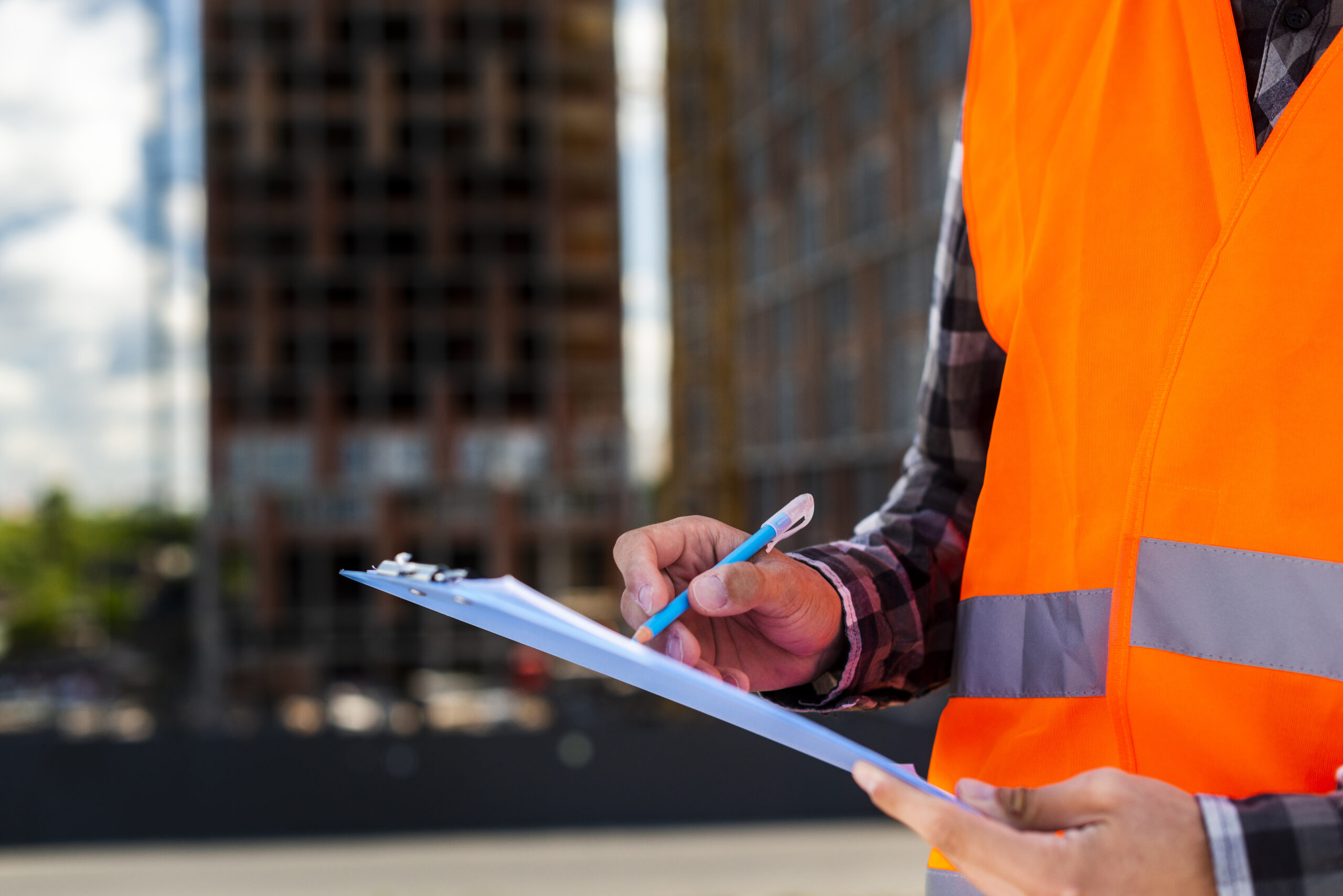 Engineer writing inspection notes on a building site