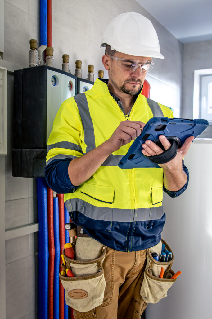Electrician inspecting a residential switchboard with a tablet